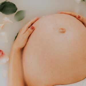 pregnant woman sitting on bathtub