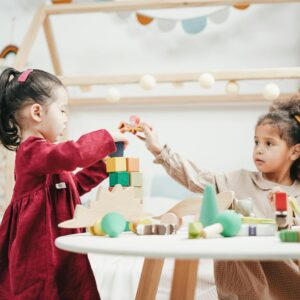 girl in red dress playing a wooden blocks