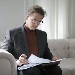 classy executive male reading papers on couch