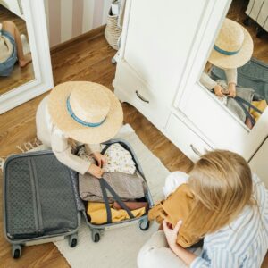 a woman and a child packing a suitcase