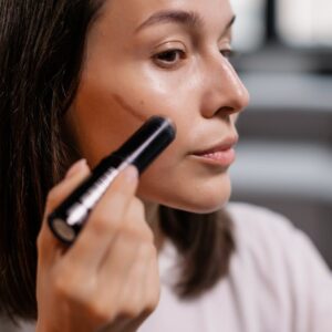 woman applying contour on her face