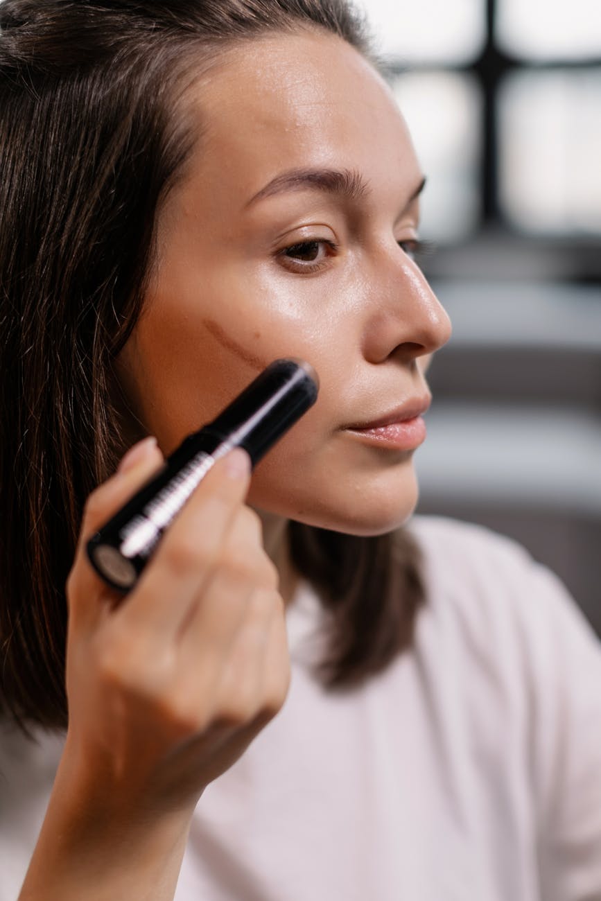 woman applying contour on her face